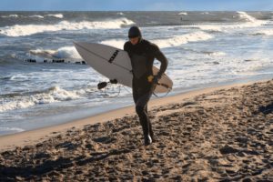 Surfer on its way to the cold water for the first heat of Cold Waves by Porsche / Poland 2023